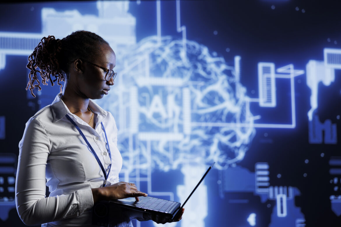 African professional using laptop with AI digital brain in background, symbolizing human creativity and jobs AI can’t replace